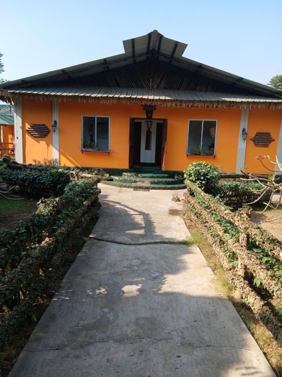 an orange house with a pathway in front of it at Longchen Homestay in Dimapur