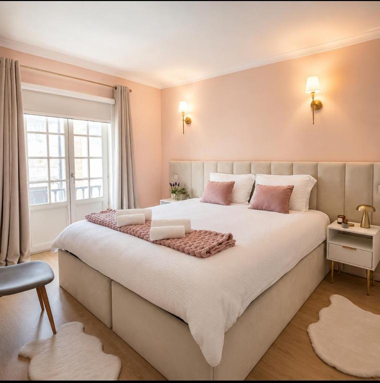 ein Schlafzimmer mit einem großen weißen Bett und rosa Kissen in der Unterkunft Opus House in Guimarães