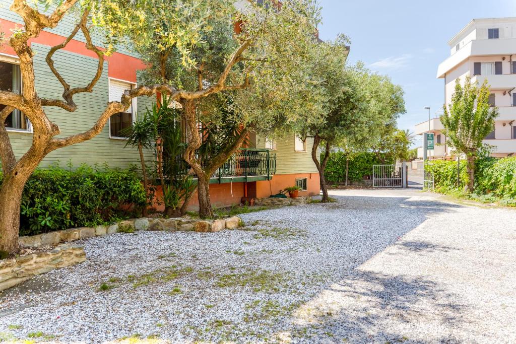 a gravel driveway in front of a house with trees at hotel La pineta in Marina di Carrara