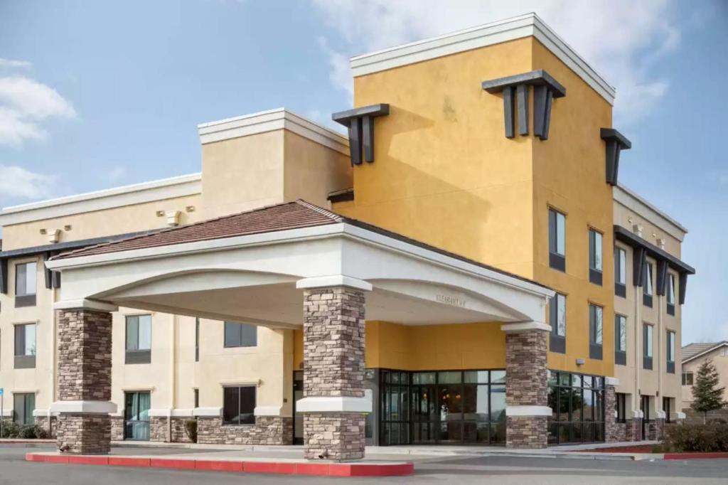 a large yellow building with an arch in front of it at University Hotel Davis Area by IHG in Dixon