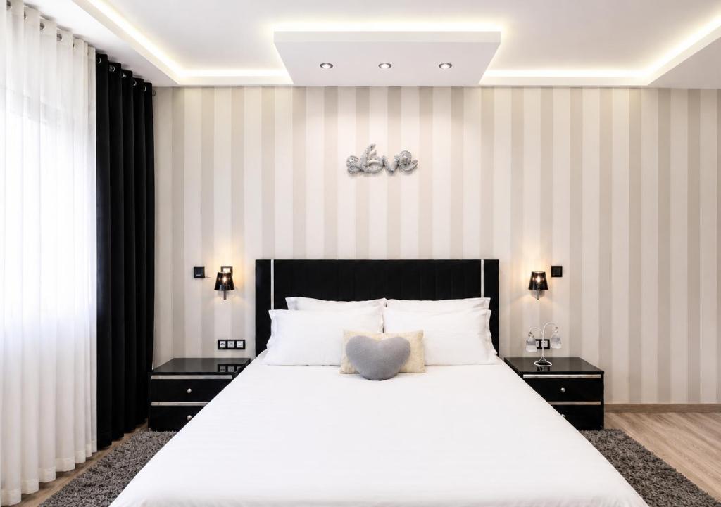 a bedroom with a large white bed and striped walls at Elegant & Bright Flat in the Heart of Tangier in Tangier