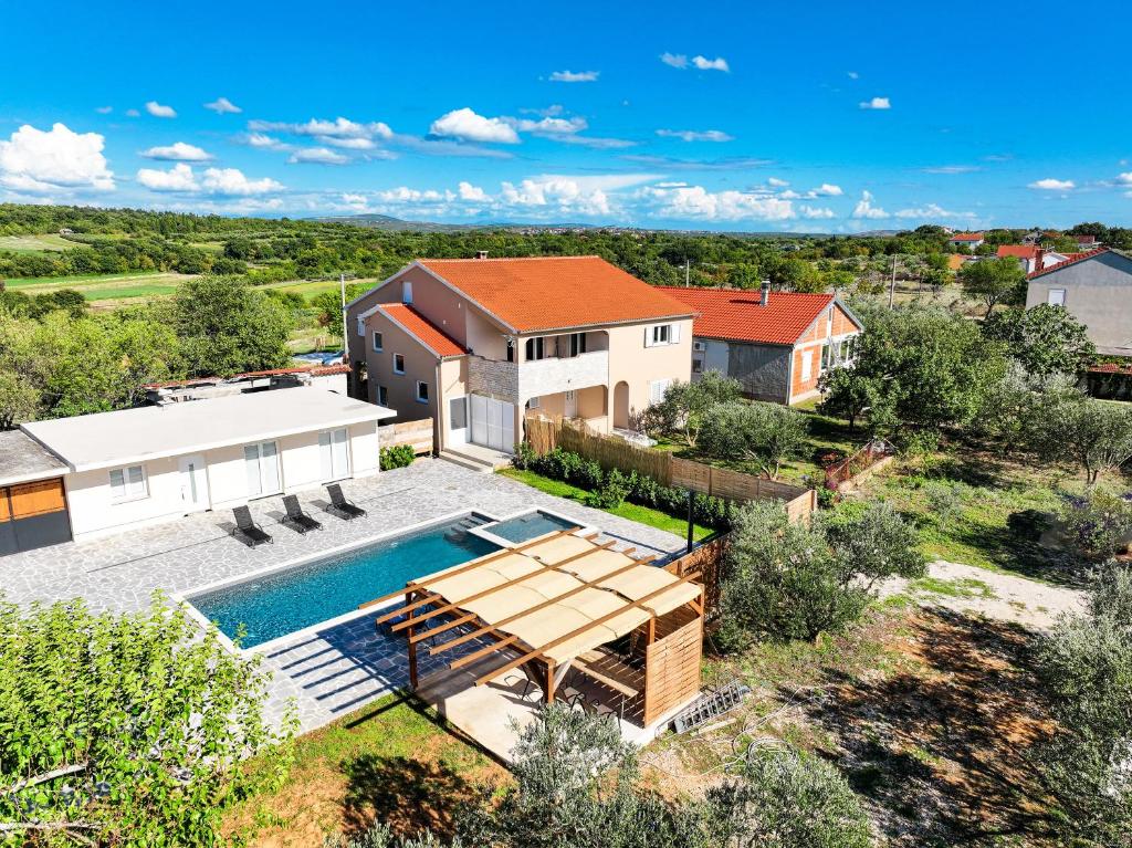 an aerial view of a home with a swimming pool and a house at OLEA Holiday Home Benkovac-private pool,garden and parking in Šopot