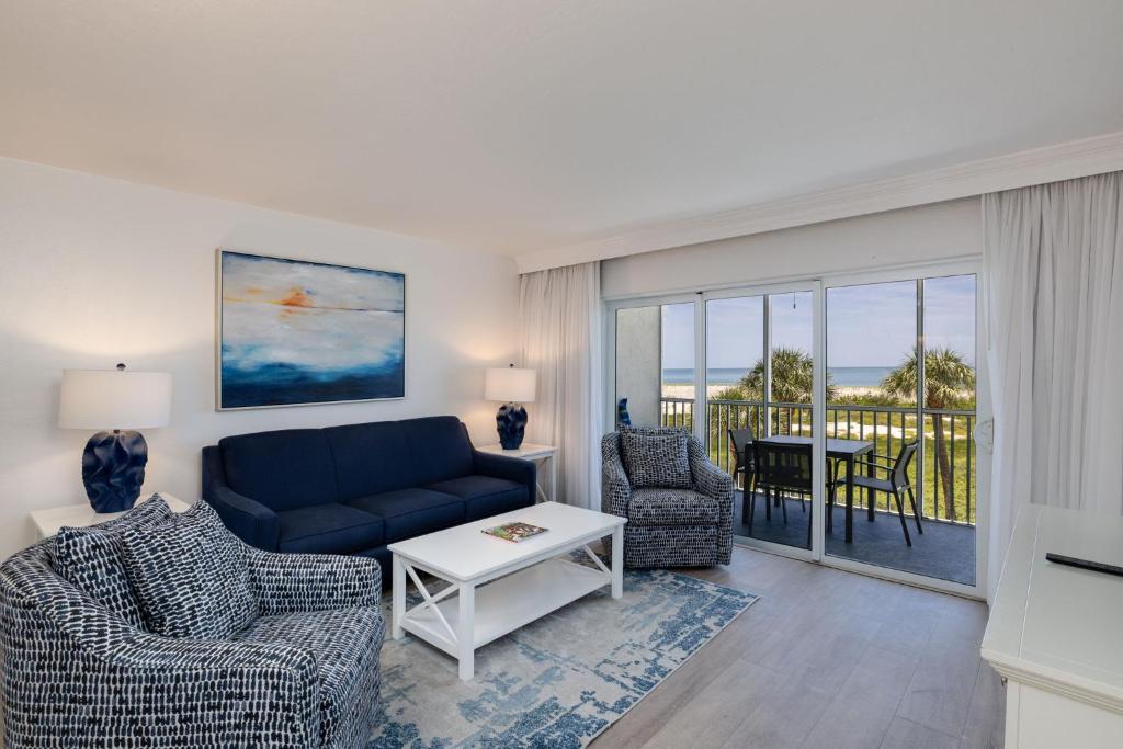 a living room with a couch and chairs and a balcony at Beach Villa 2323 - Captiva One Bedroom Deluxe Beachfront Residence in Captiva