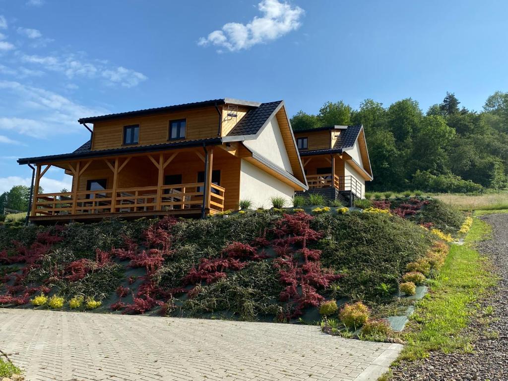 a house on top of a hill with a driveway at Domki hopSolina in Zawóz