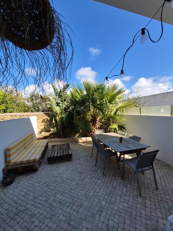 a patio with a bench and a table and chairs at Ribavilla Surf House in Santo Isidoro