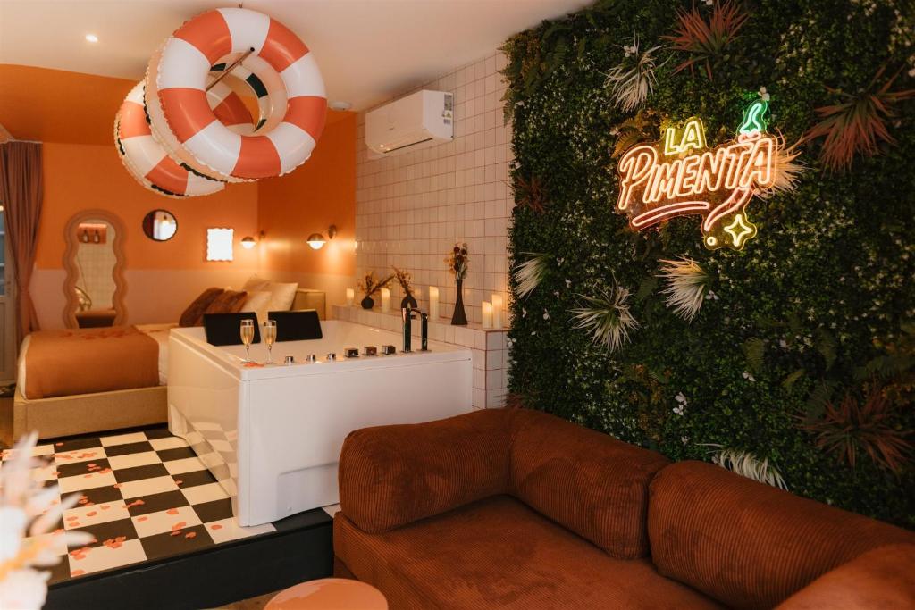 a living room with a sign on a wall at La Pimenta - SPA privatif & expérience immersive in Dole