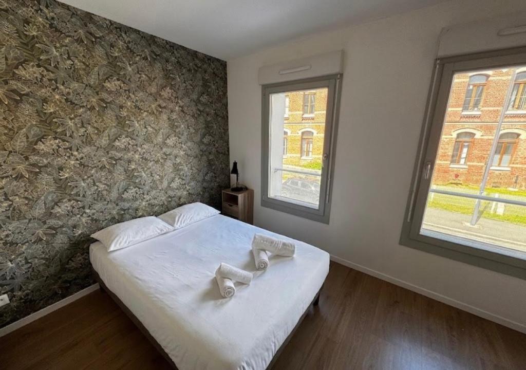 a bedroom with a bed with two towels on it at Studio Quartier Amiens in Amiens