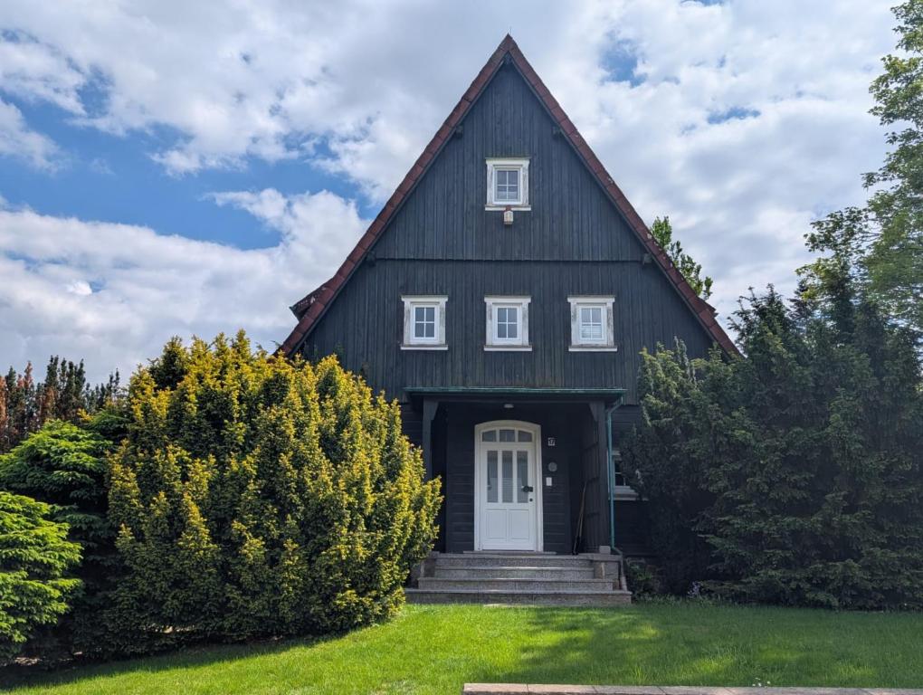 a black house with a white door at HarzHaus Hahnenklee in Hahnenklee-Bockswiese