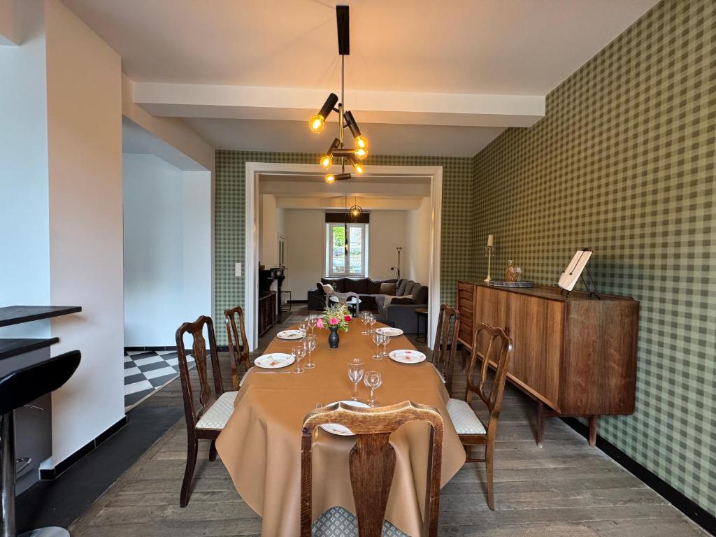 a dining room with a long table with chairs at Chez Marraine in Nassogne
