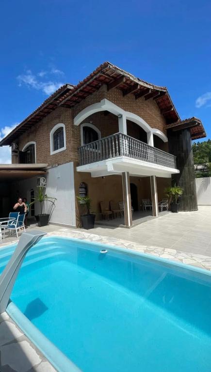 a house with a swimming pool in front of a house at Sobrado 3 Praias in Ubatuba