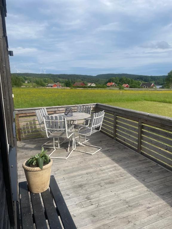 eine Terrasse mit Tisch und Stühlen und ein Feld in der Unterkunft Låbbyn15 in Årjäng