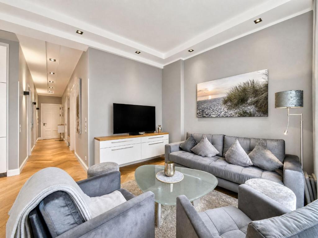 a living room with a couch and a tv at Ferienwohnung Luxus Sonnensuite in der Strandvilla Charlotte Binz in Binz
