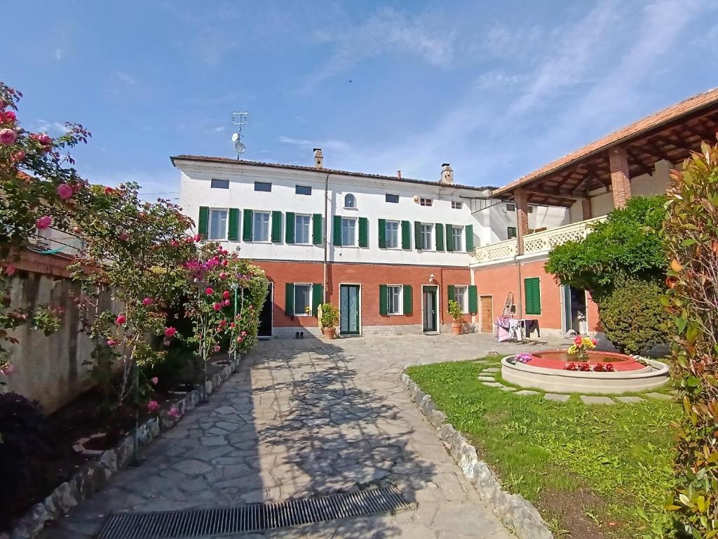 a large house with a courtyard with a fountain at La Corte della Musica in Roppolo