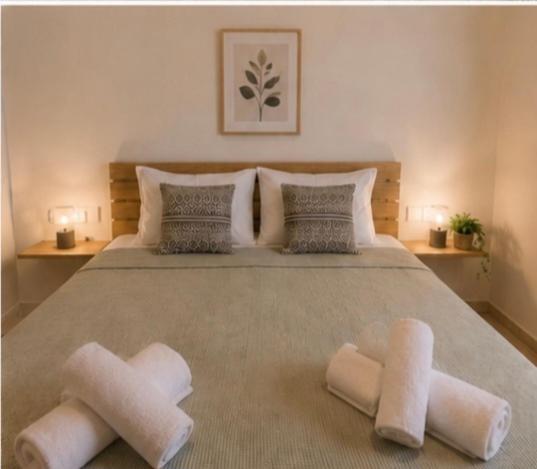 a bedroom with a large bed with two towels on it at Aurora Apartments Stavros in Stavros