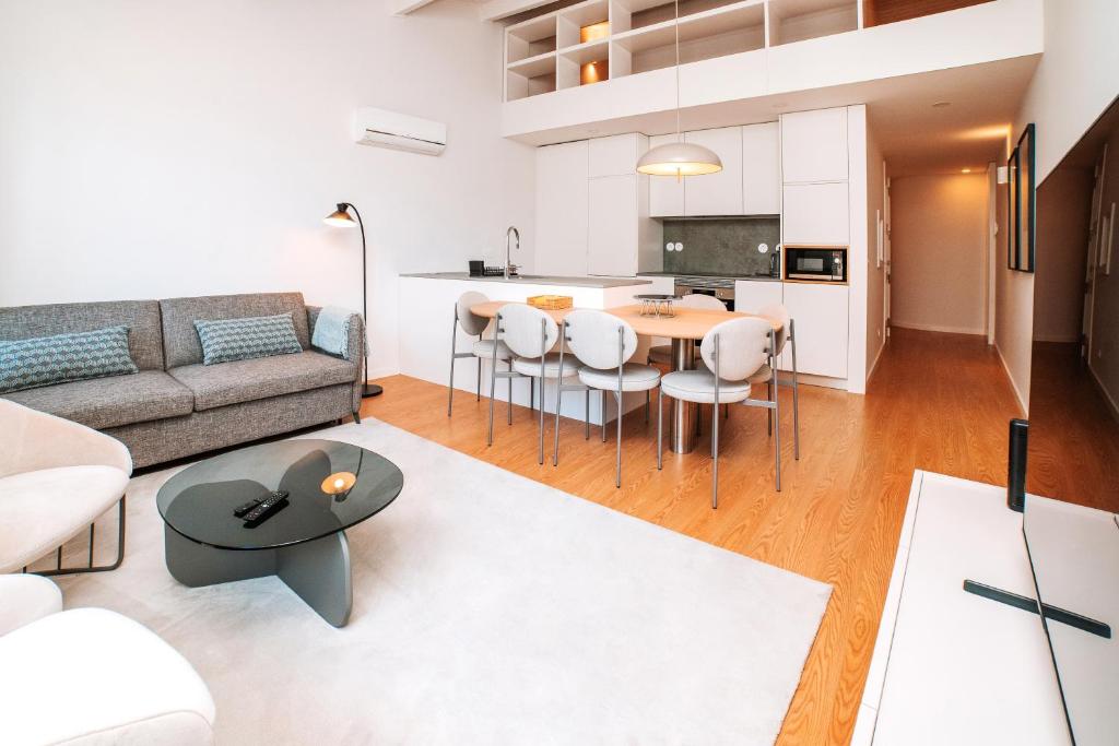 a living room with a couch and a table at Micah's Biscainhos Apartment by Quantique in Braga