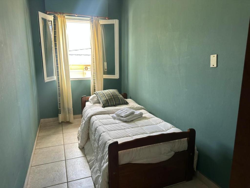 a bed in a blue room with a window at Lass Cahuelas in Federación