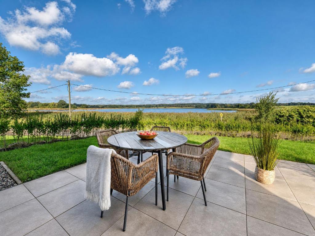 a table and chairs on a patio with a view at Ferienhaus Neukamp 17D Schilfhütte in Putbus