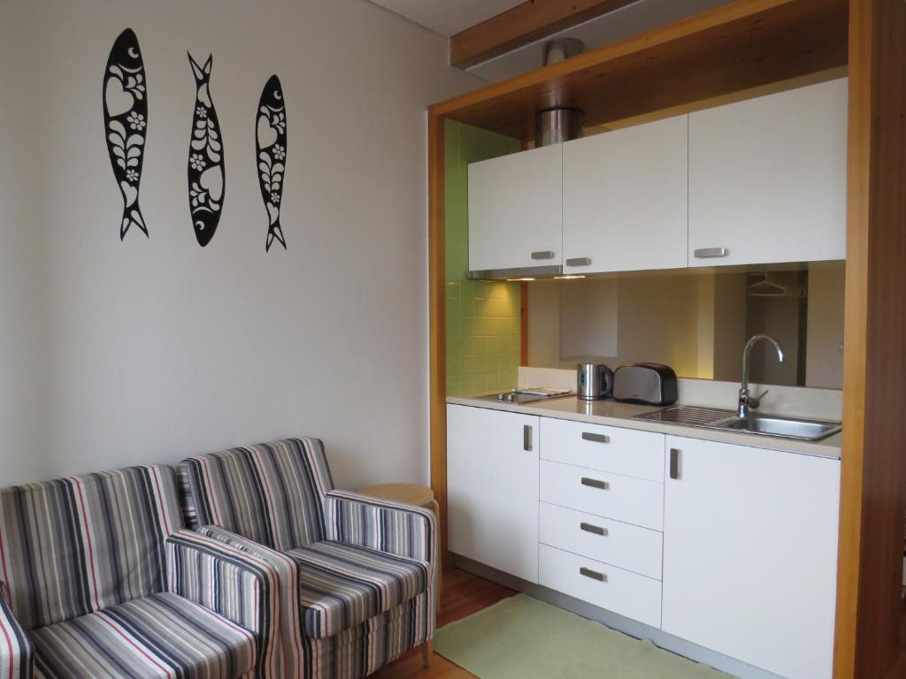 a kitchen with two chairs and a kitchen counter at Tagus Apartments by Lisbon Village Apartments in Lisbon