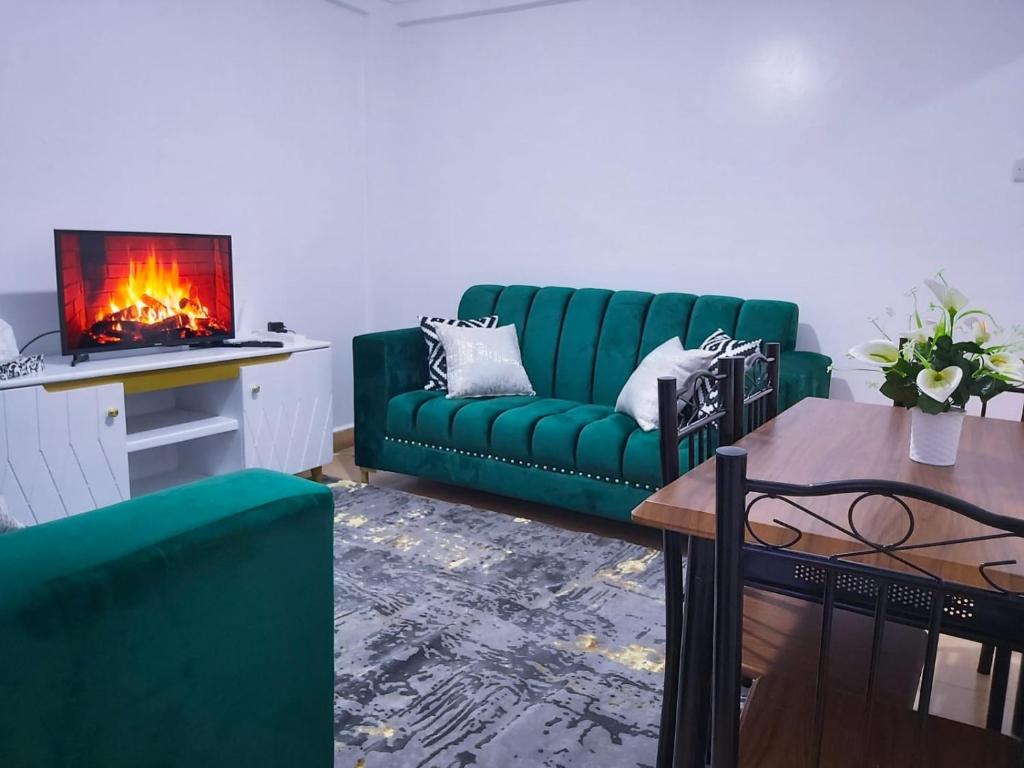 a green couch in a living room with a fireplace at Nest homes in Eldoret