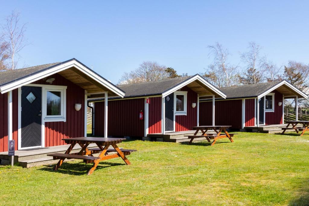 a group of picnic tables in front of a cabin at Rödlix Vandrarhem & Camping in Tvååker