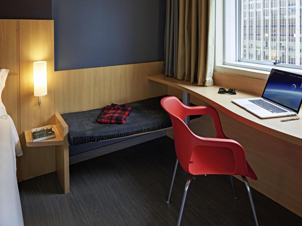 a room with a bed and a desk with a laptop at ibis Rio de Janeiro Centro in Rio de Janeiro