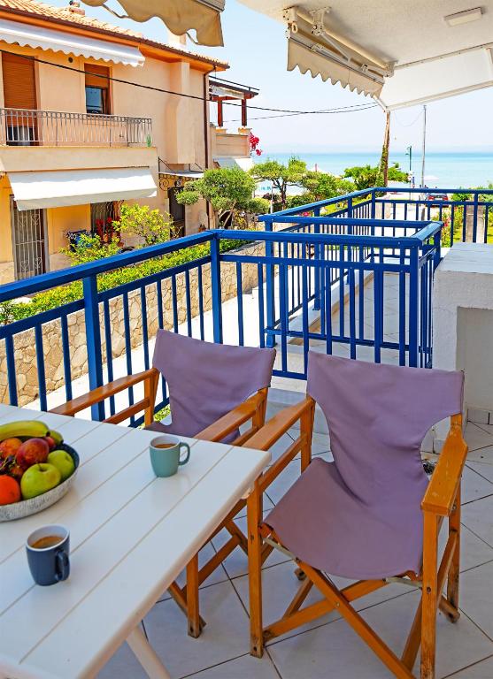 a table and chairs on a balcony with a bowl of fruit at Big Blue Pefkohori in Pefkochori