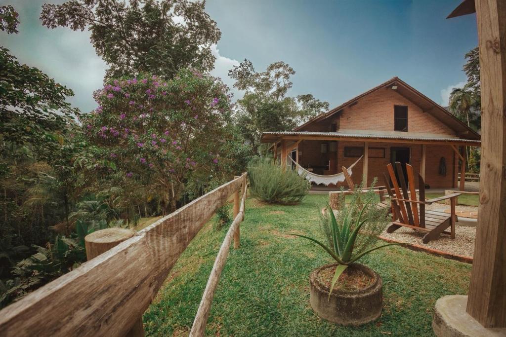 a house with a fence in front of a yard at Sitio Dona Bela - Rio da Prata in Joinville