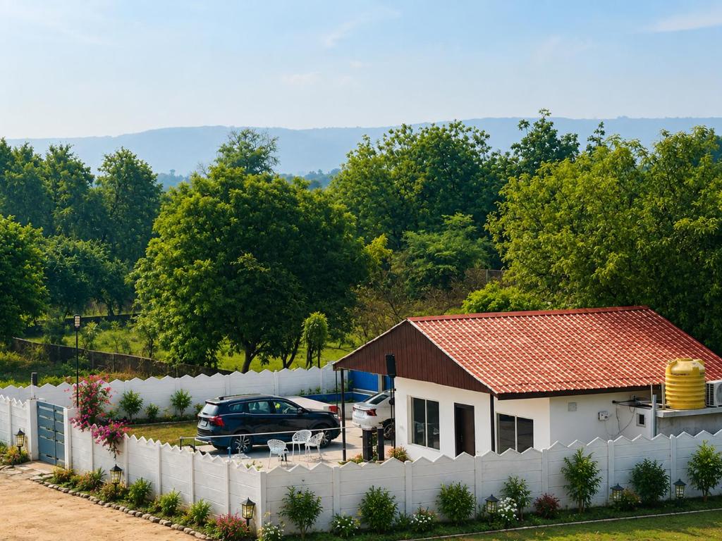 a house with a white fence and a car at Vibhor peace cottage in Chitrakoot