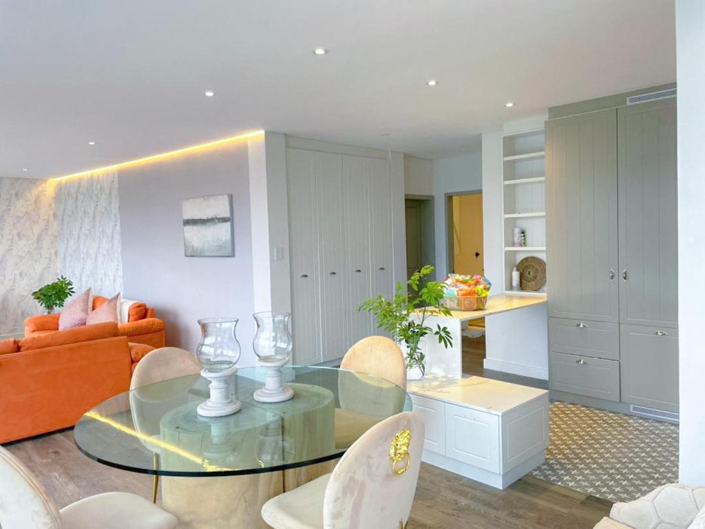a living room with a glass table and chairs at Suite 10 in Windhoek
