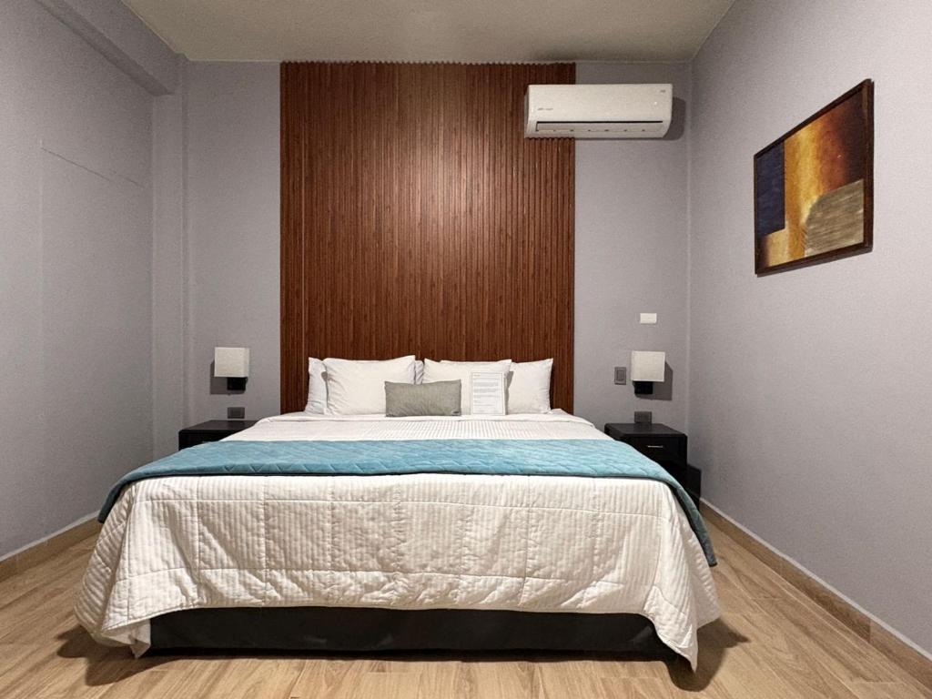 a bedroom with a large bed and two lamps at Hotel Plaza del Arco Express in Monterrey