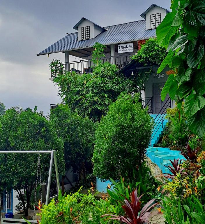 a house with a pool in front of it at Mist Farm Resort in Avanāshi