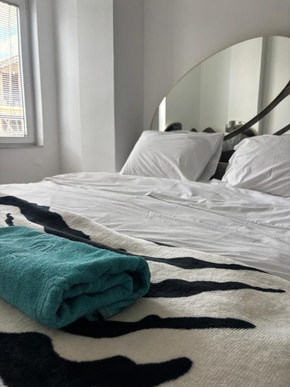 a white bed with a green towel on it at Apartment ANGELA Ohrid in Ohrid