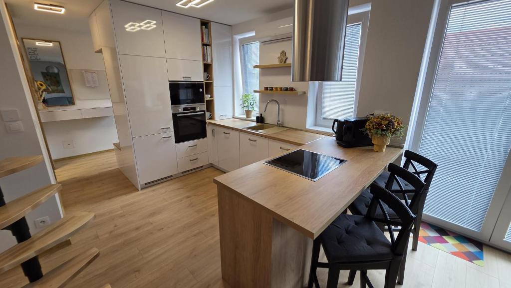 a kitchen with a large wooden island in the middle at Bytík Hlohovec Centrum in Hlohovec