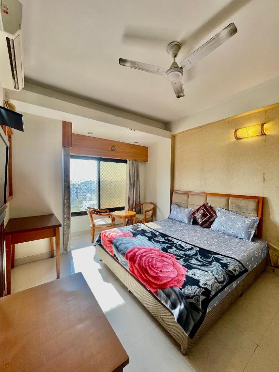 a bedroom with a bed and a table and a window at ZenRoofs - Brij Bhumi Haven 1 in Vrindāvan
