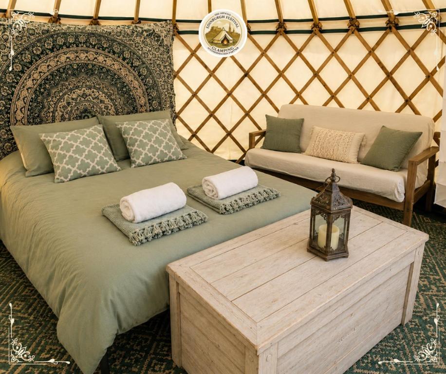 a room with a bed and a couch in a yurt at Edinburgh Festival Glamping By Stay Social Stays in Edinburgh