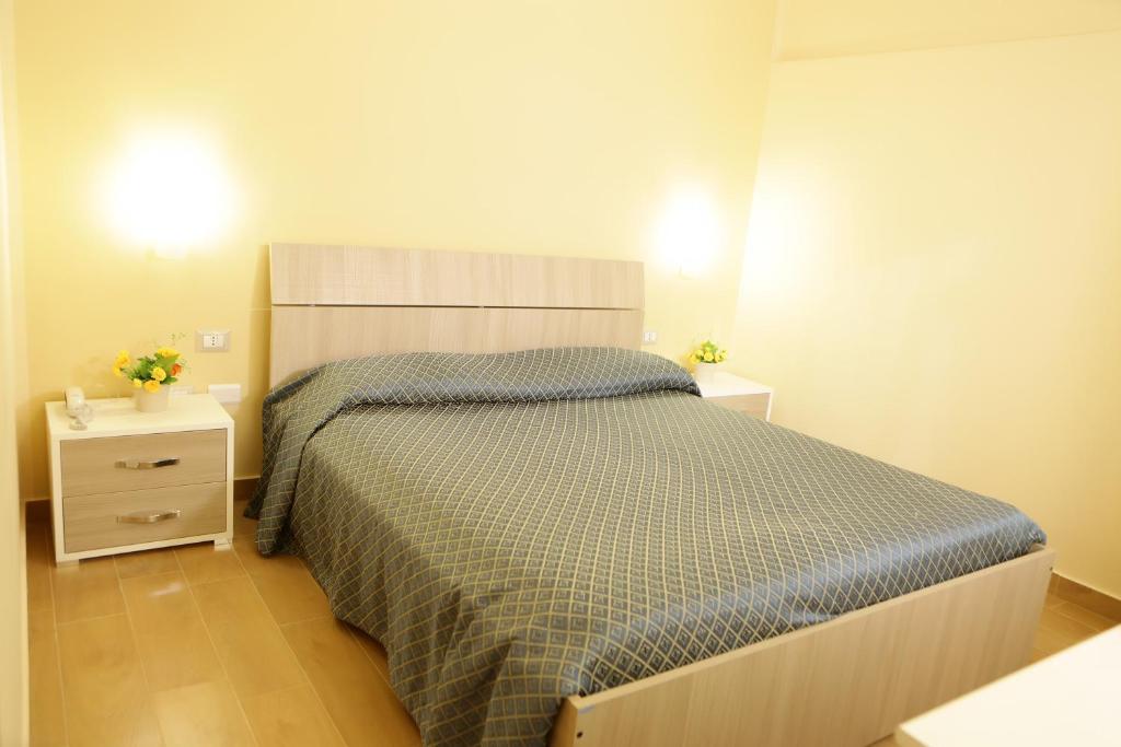 a bedroom with a large bed and two night stands at Hotel Il Quadrifoglio in Torre del Greco