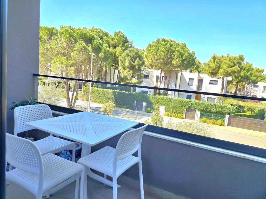 a white table and chairs on a balcony with a view at Wide Beach Apartments 236 in Mullini i Danit