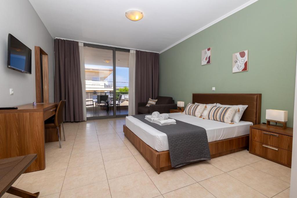 a bedroom with a bed and a desk and a television at Centrum Rooms in Kallithea Halkidikis