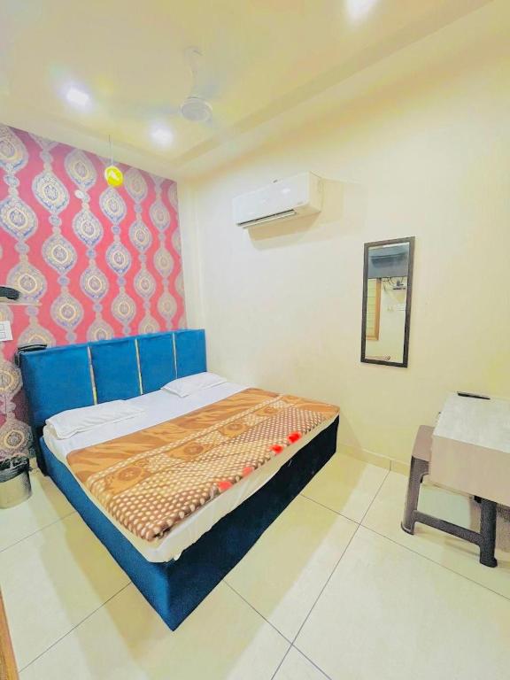 a bedroom with a blue bed and a chair at Hotel RKS Residency in Bathinda