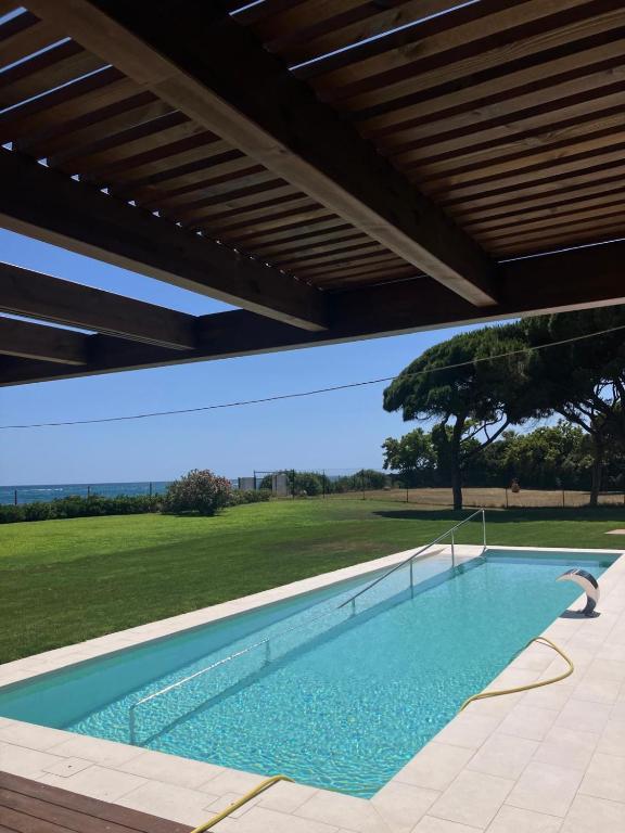 a swimming pool under a pavilion with a view of a field at El setè cel in Malgrat de Mar