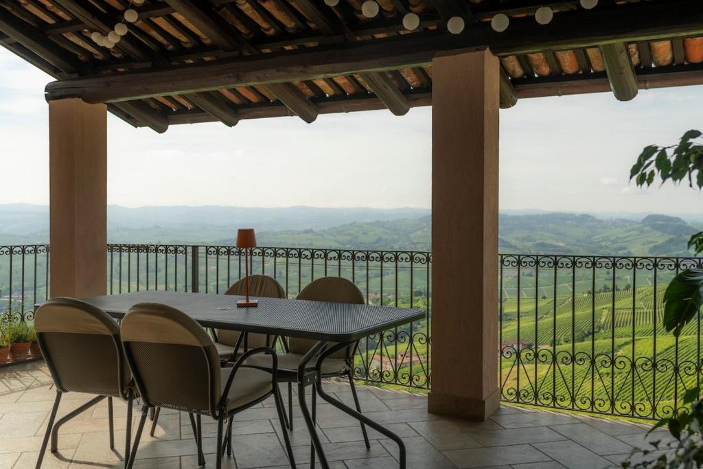 a table and chairs on a balcony with a view at Sky & Vineyards - Melograno - in La Morra