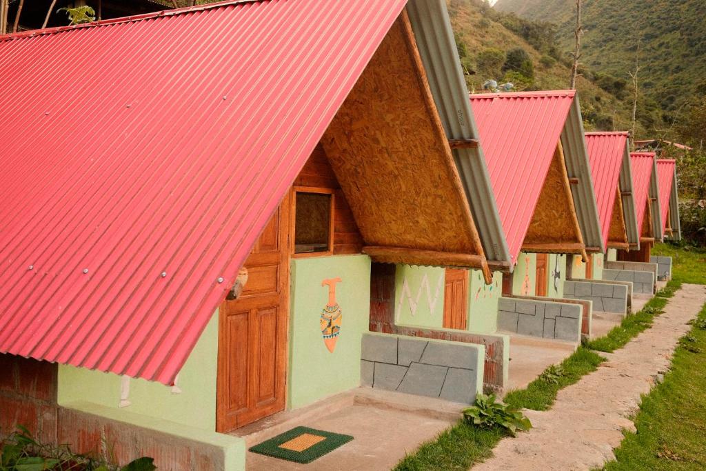 a row of small houses with red roofs at Pablito Hostel Challhuay in Colcapampa