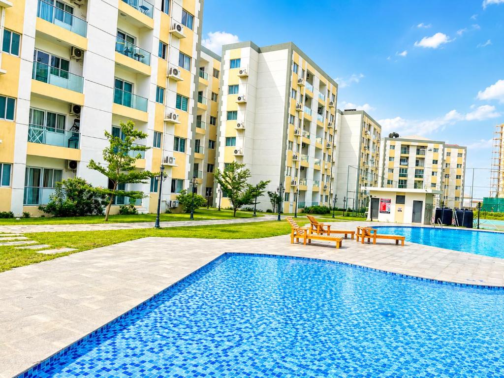 a swimming pool with benches in front of a building at Residential Capital Plus in Accra