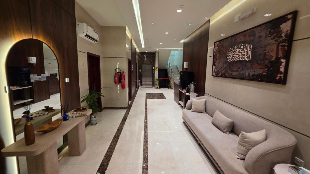 a living room with a couch and a mirror at سجى الهدوء للشقق المخدومة in Abha