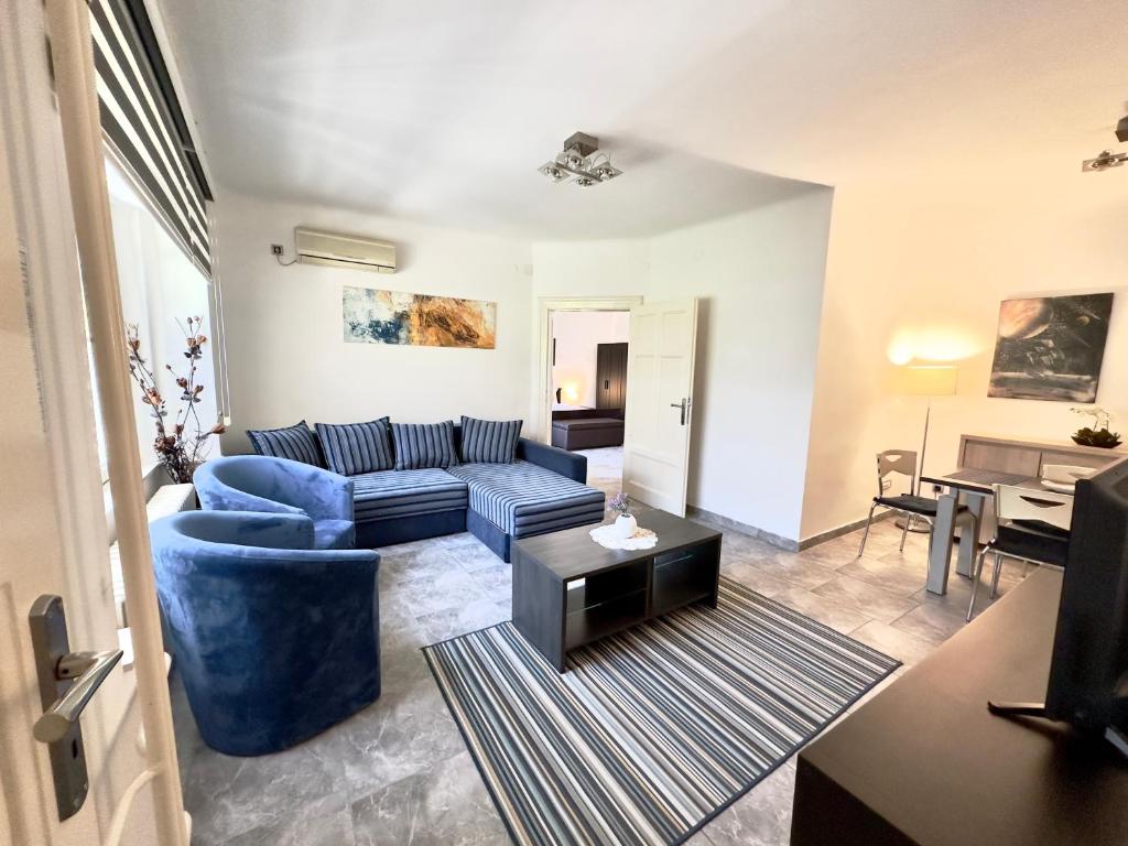a living room with a blue couch and a table at Q-Art Hidden Garden City Centre in Novi Sad