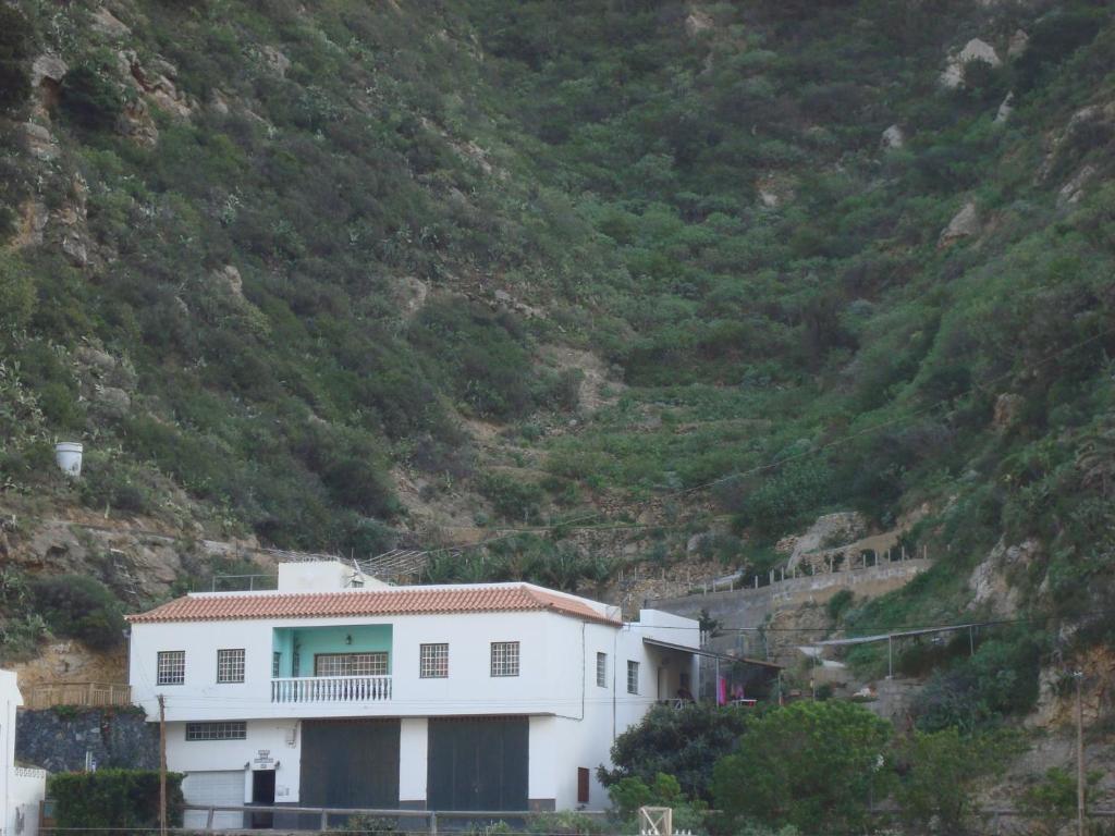 une maison blanche sur le côté d'une montagne dans l'établissement Casa Las Dionisias, à Vallehermoso