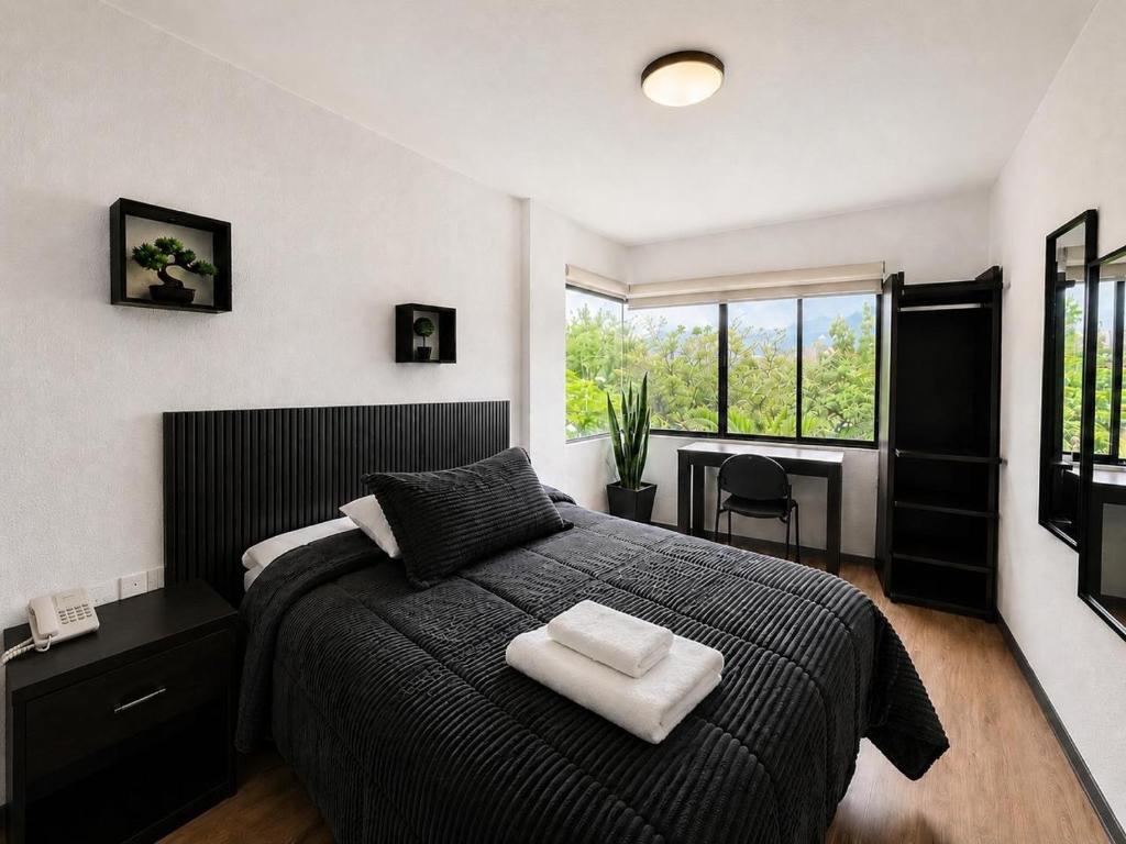 a bedroom with a bed with two towels on it at Hotel Bellavista Quito in Quito