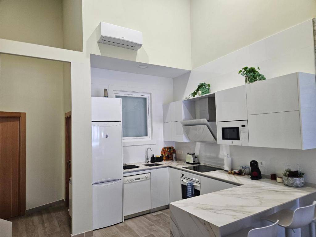 a white kitchen with white cabinets and a counter at La Herencia A VuT 1229 in Ponferrada