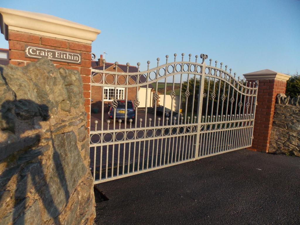 a white gate in front of a house at Craig Eithin B & B in Holyhead