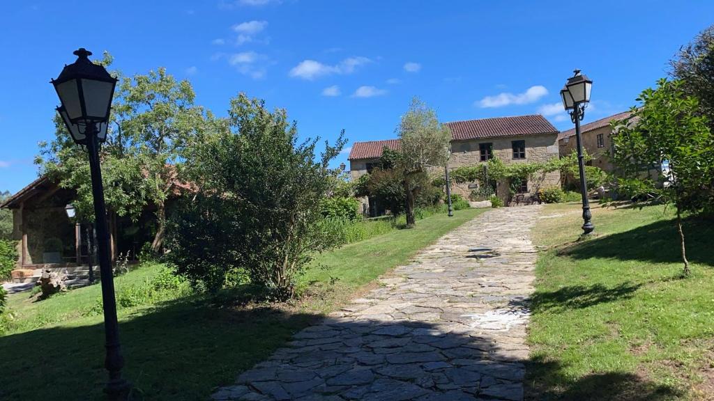 two lampposts on a stone path in front of a house at Casa Gasamáns in Amés